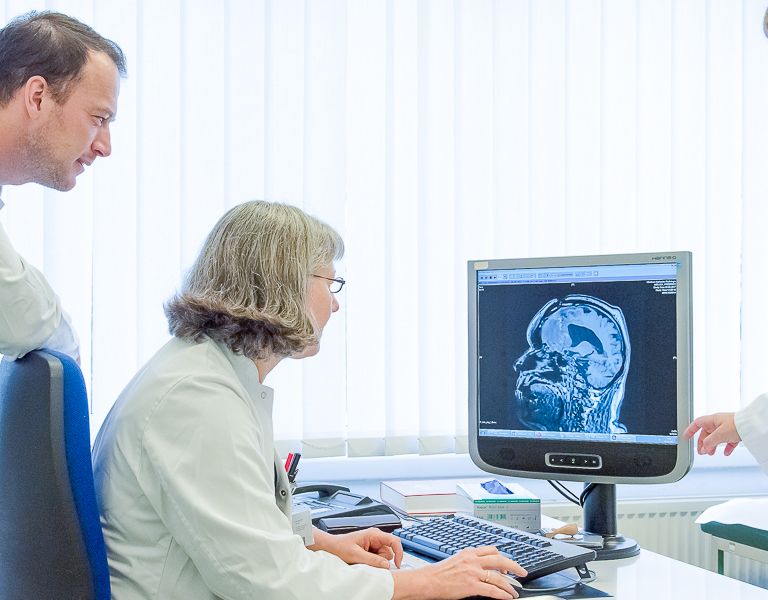 Das Bild zeigt ein Ärzteteam Gespräch bei der Diagnose am PC