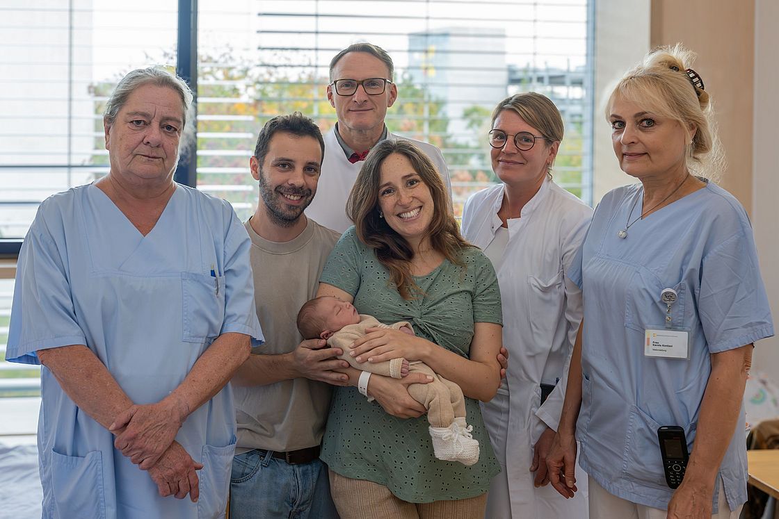 Das Bild zeigt Miguel im Kreise seiner Eltern und des Teams der Frauenklinik