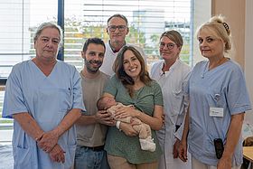 Das Bild zeigt Miguel im Kreise seiner Eltern und des Teams der Frauenklinik